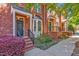 Charming brick townhomes with black doors, bay windows, and colorful landscaping along the sidewalk at 110 Tressel Way, Durham, NC 27707