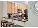 Stylish kitchen featuring wood cabinets, granite countertop seating, and modern appliances at 110 Tressel Way, Durham, NC 27707