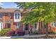 Brick townhomes featuring black-trimmed windows and entryways, complemented by lush landscaping at 110 Tressel Way, Durham, NC 27707