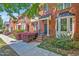 Charming brick townhomes with manicured landscaping and inviting front entrances on a sunny day at 110 Tressel Way, Durham, NC 27707
