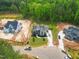 Aerial view of new home construction featuring landscaping, driveways, and large wooded lots at 1108 Delilia Ln, Wake Forest, NC 27587