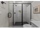 An elegant bathroom showcasing a glass shower, a niche, and a contemporary design with dark fixtures at 1108 Delilia Ln, Wake Forest, NC 27587