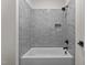 A stylish bathroom with a gray tiled shower and a white bathtub with black fixtures at 1108 Delilia Ln, Wake Forest, NC 27587
