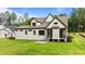 View of the house with white siding, dark trim, screened porch, and a well-maintained green lawn at 1108 Delilia Ln, Wake Forest, NC 27587