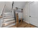 Entryway with staircase featuring wood steps, iron railings, and a custom built-in storage bench with hooks and baskets at 1108 Delilia Ln, Wake Forest, NC 27587