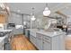 Open kitchen with stainless appliances, white farmhouse sink, and hardwood floors at 1108 Delilia Ln, Wake Forest, NC 27587