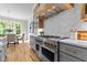 Chef's kitchen featuring a professional-grade range, custom cabinetry, and stylish herringbone backsplash at 1108 Delilia Ln, Wake Forest, NC 27587