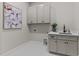 A utility room featuring built in white cabinets, decor, sink with black faucet, and herringbone pattern tile at 1108 Delilia Ln, Wake Forest, NC 27587
