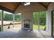Covered patio with wood ceiling, grey floors, an outdoor fireplace, and a view of wooded backyard at 1108 Delilia Ln, Wake Forest, NC 27587