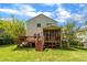 Backyard view showcasing a well-maintained lawn, spacious deck and screened-in porch at 1198 Shining Water Ln, Creedmoor, NC 27522