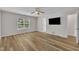 Bedroom with neutral walls, ceiling fan, bright window, and wood-look floors at 1198 Shining Water Ln, Creedmoor, NC 27522