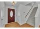 Inviting foyer with a red door, staircase, and hardwood floors at 1198 Shining Water Ln, Creedmoor, NC 27522