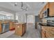 Well-lit kitchen with island, granite countertops, stainless appliances, grey tile floors, and wooden cabinets at 1198 Shining Water Ln, Creedmoor, NC 27522