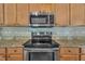 Beautiful kitchen featuring updated appliances, granite countertops, and decorative backsplash tiles at 1198 Shining Water Ln, Creedmoor, NC 27522