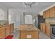 Bright kitchen with an island featuring a granite countertop, stainless steel appliances, and ample cabinet space at 1198 Shining Water Ln, Creedmoor, NC 27522