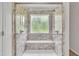 Marble-look shower with dual shower heads, a built in bench, and bright window at 1198 Shining Water Ln, Creedmoor, NC 27522