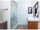 Bathroom showcasing a glass-enclosed shower and a double vanity with modern fixtures and light blue walls at 130 Hunt St # 107, Durham, NC 27701