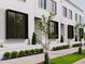 Charming townhome exterior featuring crisp white brick, black framed windows, and landscaped front yards at 1302 Chamblee Hill Ct, Raleigh, NC 27608