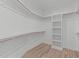 Bright walk-in closet featuring custom shelving, hanging rods and hardwood flooring at 1302 Chamblee Hill Ct, Raleigh, NC 27608
