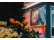 A partially obstructed view of Godman's Comedy Club building through greenery and flowers at 1303 Chamblee Hill Ct, Raleigh, NC 27608