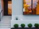 Elegant white brick front entrance with modern black door and manicured greenery at 1303 Chamblee Hill Ct, Raleigh, NC 27608