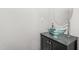Modern bathroom with a glass vessel sink atop a sleek vanity and a round mirror at 1307 Torrey Pines Ct, Mebane, NC 27302