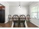 Formal dining room with dark wood floors, neutral walls, and a modern chandelier above the table at 1307 Torrey Pines Ct, Mebane, NC 27302