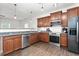 Well-equipped kitchen offering stainless steel appliances, dark cabinets, granite counters, and hardwood floors at 1307 Torrey Pines Ct, Mebane, NC 27302