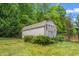 Charming backyard shed surrounded by lush greenery and a manicured lawn at 1307 Torrey Pines Ct, Mebane, NC 27302