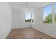 Bright bedroom features hardwood floors, a ceiling fan, and large windows with green tree views at 1308 Chamblee Hill Ct, Raleigh, NC 27608
