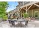 Backyard patio with outdoor dining area, fireplace with seating, and a swing with string lights at 1308 Green Oaks Pkwy, Holly Springs, NC 27540