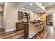 Custom basement bar featuring wood paneling, brass barstools, a granite countertop, and custom shelving at 1308 Green Oaks Pkwy, Holly Springs, NC 27540
