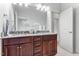 Bathroom featuring double sinks, granite countertops and dark wood cabinets at 1308 Green Oaks Pkwy, Holly Springs, NC 27540