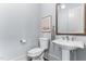 Cozy half bath featuring a pedestal sink, framed mirror, and artwork, perfect for guests at 1308 Green Oaks Pkwy, Holly Springs, NC 27540