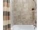 Clean bathroom showcasing a bathtub with neutral tiled walls and a shower fixture at 1308 Green Oaks Pkwy, Holly Springs, NC 27540