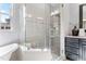 Close up of a glass shower with stone mosaic tile and a dark vanity at 1308 Green Oaks Pkwy, Holly Springs, NC 27540