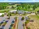 Aerial view of the clubhouse, which includes parking, mature trees, and landscape at 1308 Green Oaks Pkwy, Holly Springs, NC 27540