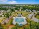 Aerial view of a community pool and clubhouse surrounded by lush landscaping and well-maintained homes at 1308 Green Oaks Pkwy, Holly Springs, NC 27540