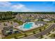 Aerial view of a community pool and playground surrounded by well-maintained homes and lush landscaping at 1308 Green Oaks Pkwy, Holly Springs, NC 27540