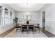Elegant dining room featuring a tray ceiling, wainscoting, modern light fixture and wood floors at 1308 Green Oaks Pkwy, Holly Springs, NC 27540