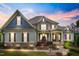 Beautiful two-story home featuring manicured landscaping, stone accents, and inviting covered front porch at 1308 Green Oaks Pkwy, Holly Springs, NC 27540