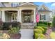 Inviting front porch with stone columns, double doors with glass, and manicured landscaping at 1308 Green Oaks Pkwy, Holly Springs, NC 27540