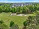 An aerial view of the lush golf course, mature trees, and neighborhood homes at 1308 Green Oaks Pkwy, Holly Springs, NC 27540