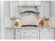 Well-appointed kitchen features granite countertops, white cabinets, and a modern gas range at 1308 Green Oaks Pkwy, Holly Springs, NC 27540
