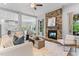 Inviting living room features a stone fireplace, a ceiling fan, and views into the kitchen and dining area at 1308 Green Oaks Pkwy, Holly Springs, NC 27540