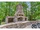 Stone outdoor fireplace with custom built shelving and stone seating at 1308 Green Oaks Pkwy, Holly Springs, NC 27540