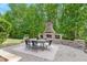 Cozy outdoor living featuring a stone fireplace, seating and dining area at 1308 Green Oaks Pkwy, Holly Springs, NC 27540