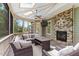Relaxing screened porch with a stone fireplace and comfortable seating for outdoor enjoyment at 1308 Green Oaks Pkwy, Holly Springs, NC 27540
