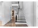 Staircase with wood floors, white trim, black railing, and a view into the living room at 1308 Green Oaks Pkwy, Holly Springs, NC 27540
