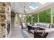 Bright sunroom features a stone fireplace, skylights, comfortable seating, and views of the wooded backyard at 1308 Green Oaks Pkwy, Holly Springs, NC 27540